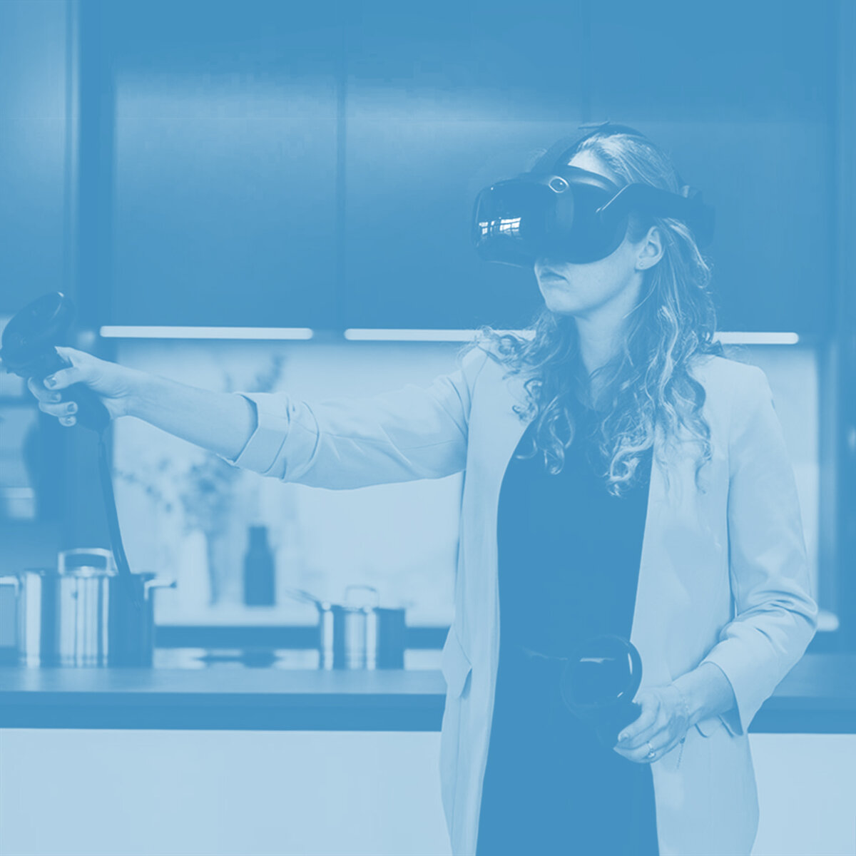 Eine Frau bedient eine VR-Brille und steht in einer Küche